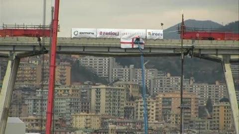 Sul pezzo di ponte Morandi da portare giù posizionata la bandiera di Genova